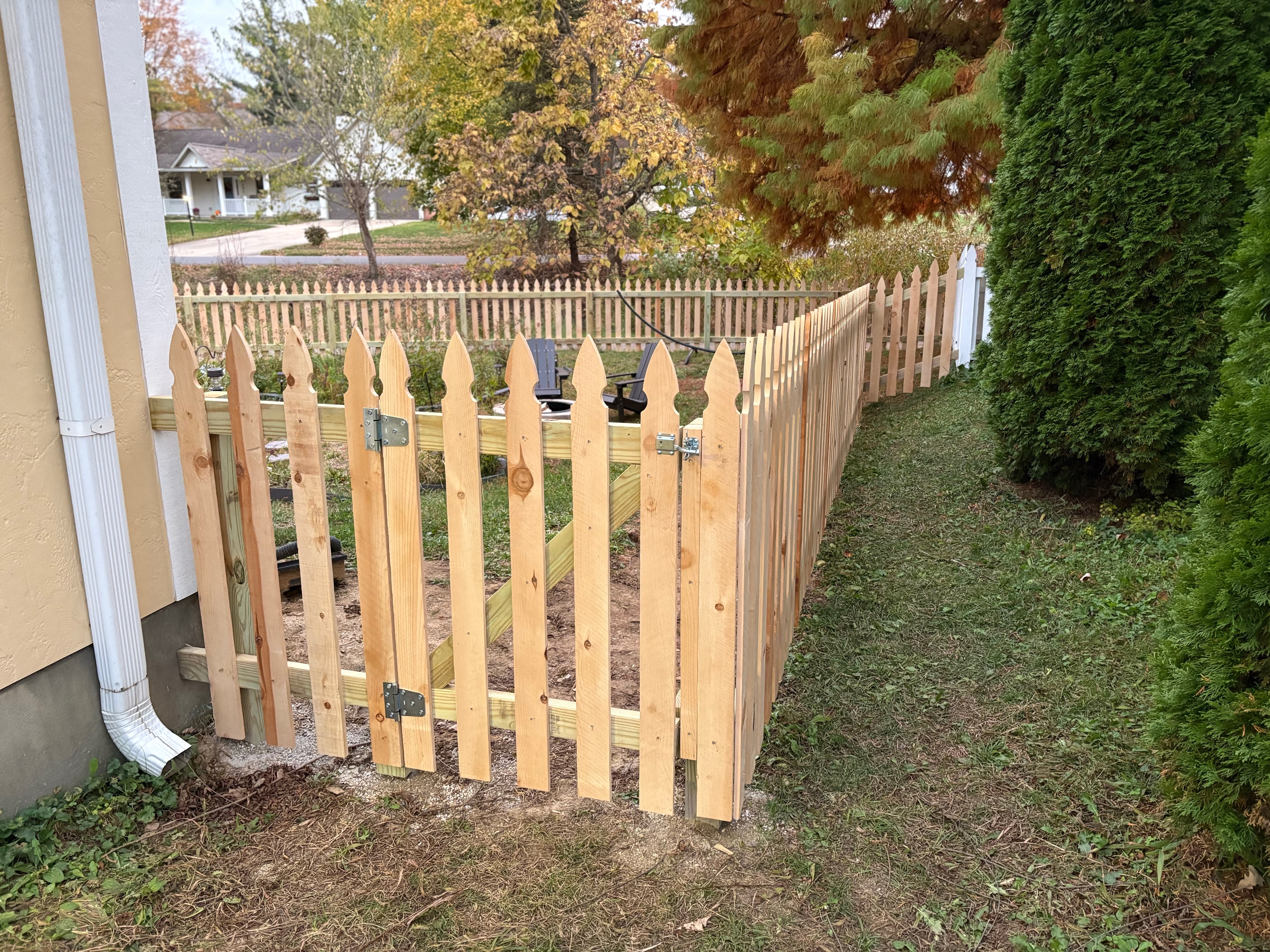 Gothic picket fence with a matching gate, pointed picket tops