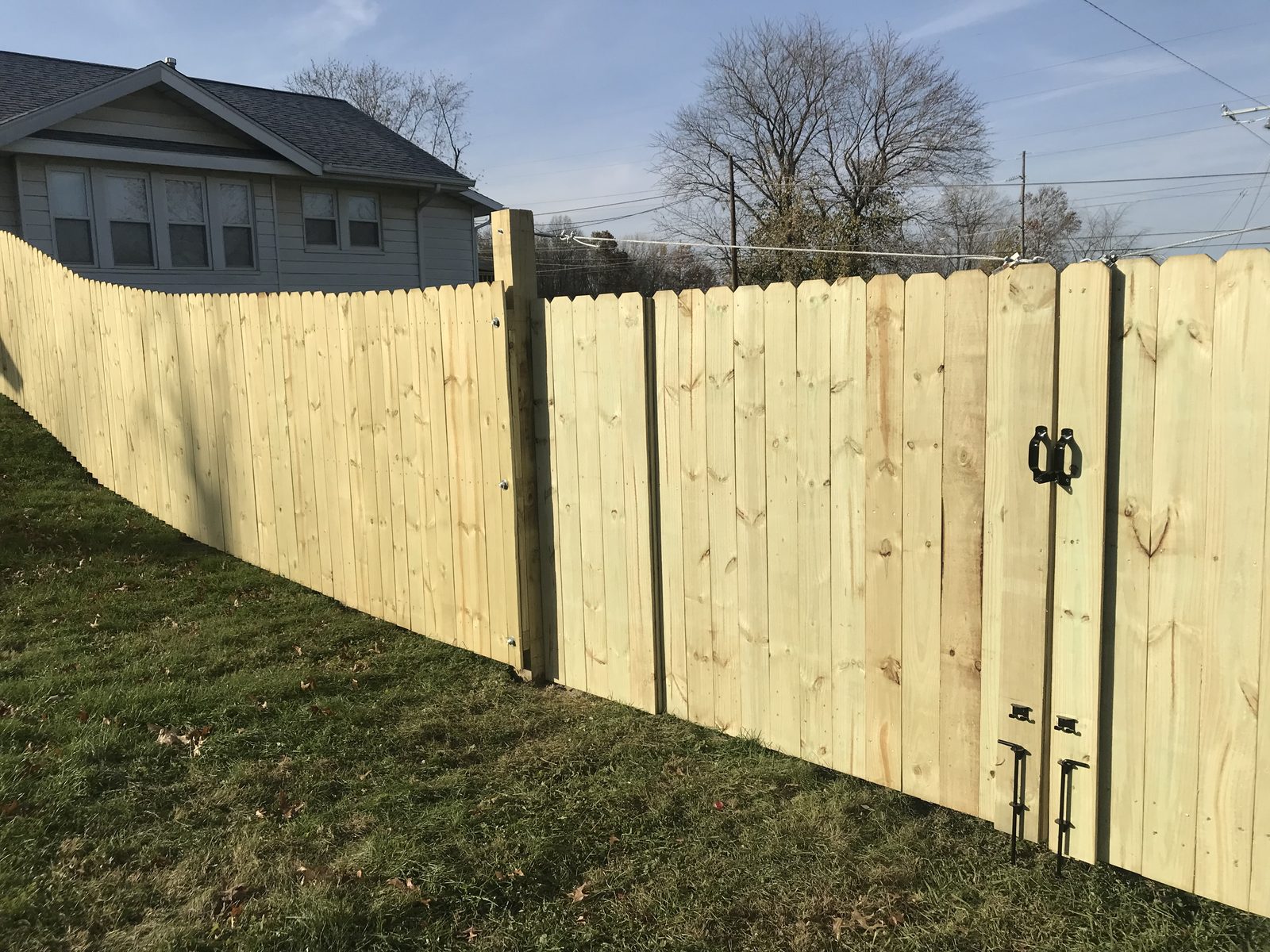 Six foot dog-ear privacy fence with a double gate